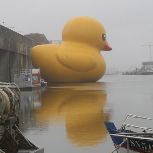 I'm big and yellow and floating in a dockyard. What am I?